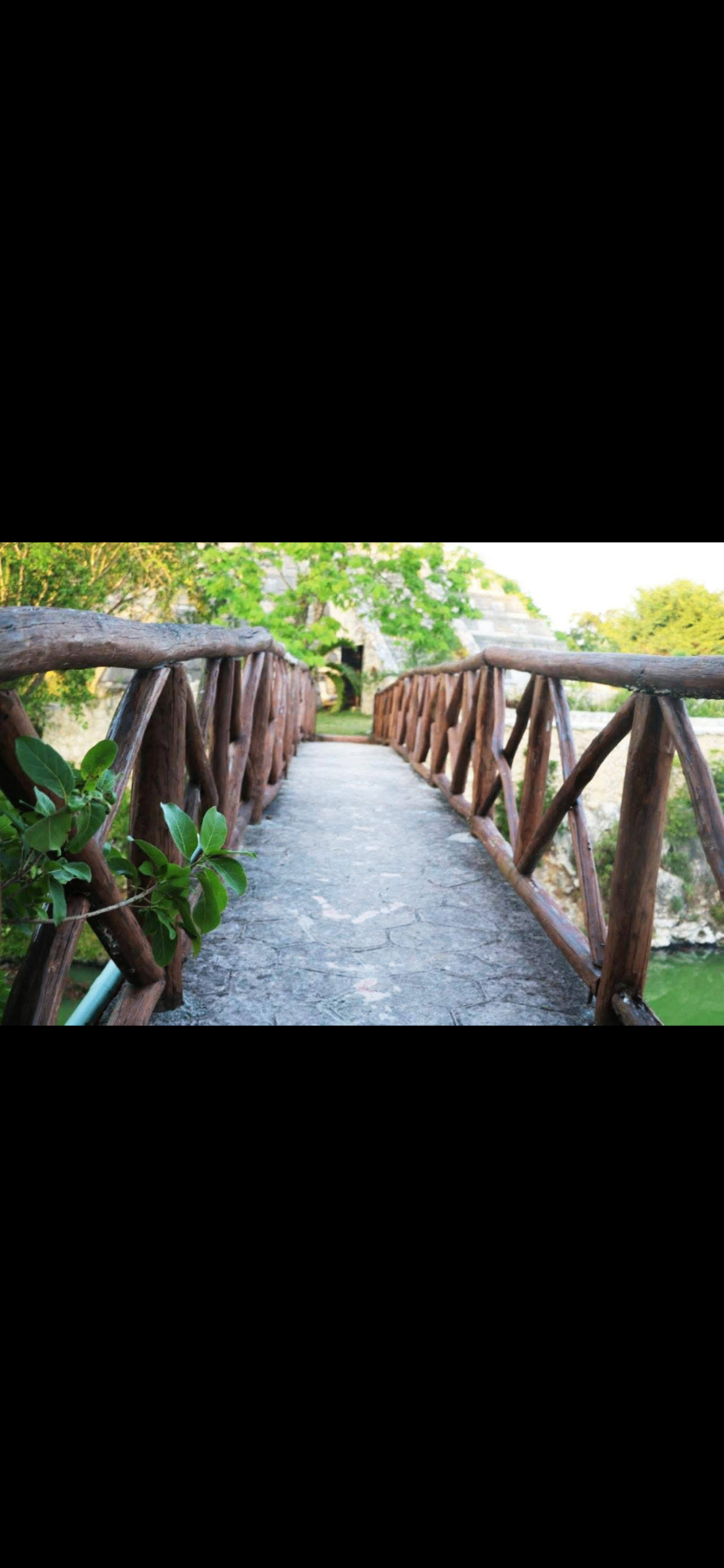 Puente de madera con vista a la pirámide